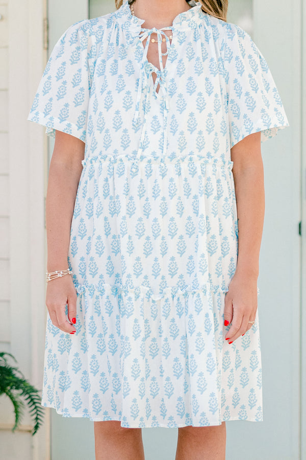 Plus Size white cotton dress with blue floral print, split neckline, neck ties, and tiered skirt.