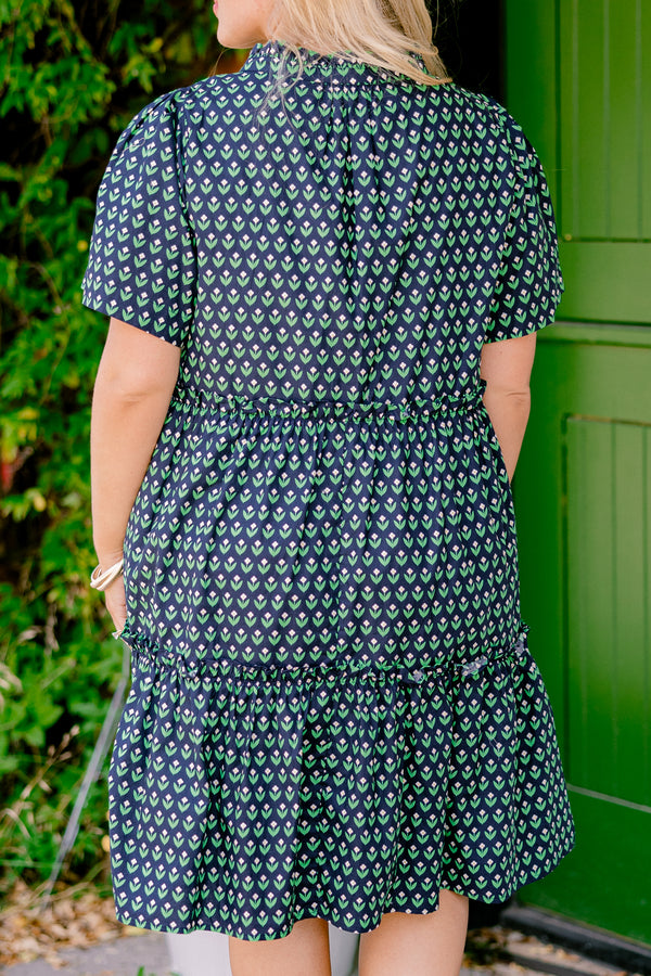 Chic Soul plus size clothing, navy floral baby doll dress that has short sleeves and a floral block pattern throughout as well has two bows that tie across the v-neckline 
