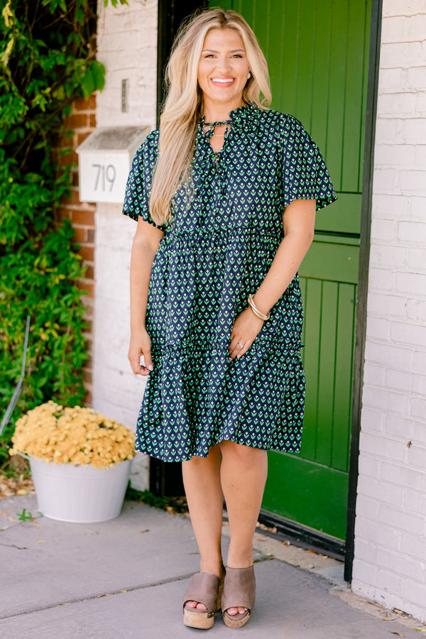 Chic Soul plus size clothing, navy floral baby doll dress that has short sleeves and a floral block pattern throughout as well has two bows that tie across the v-neckline 
