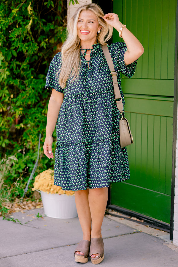Chic Soul plus size clothing, navy floral baby doll dress that has short sleeves and a floral block pattern throughout as well has two bows that tie across the v-neckline 
