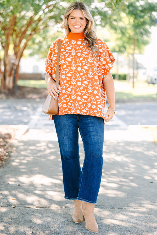 Plus Size rust orange short sleeve mock neck sweater with a white floral knit pattern.