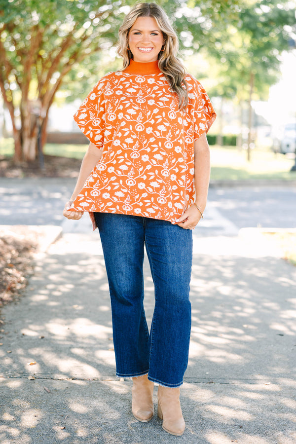 Plus Size rust orange short sleeve mock neck sweater with a white floral knit pattern.