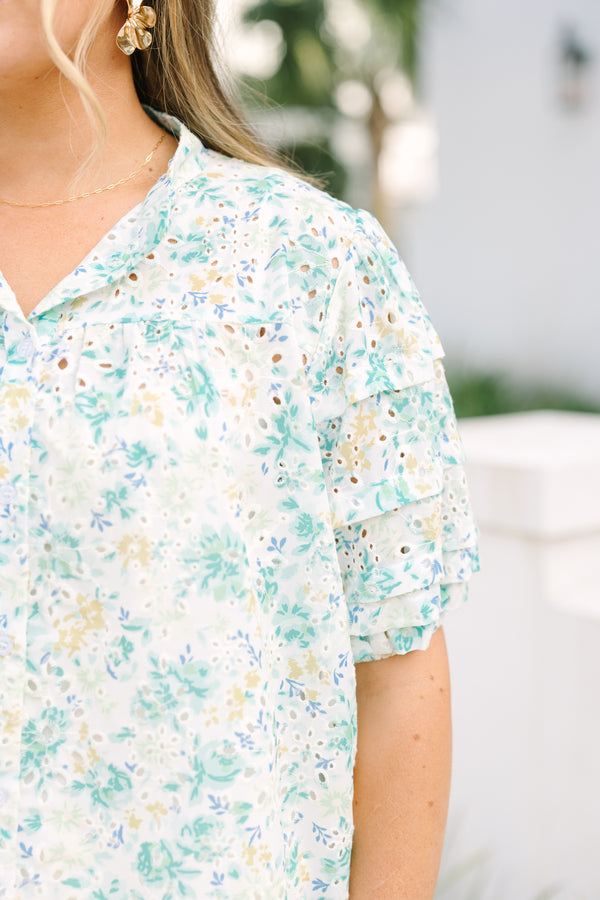 Chic Soul plus size clothing, white top with short sleeves that have eyelet detailing on the sleeves as well as a multi-color floral pattern throughout the top and buttons going down the center of the shirt 
