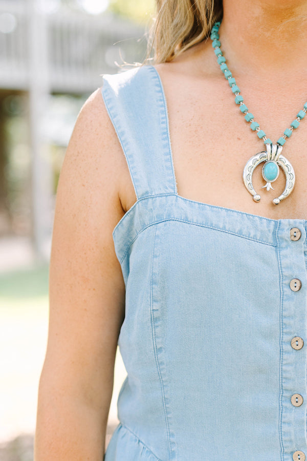 Plus Size light wash denim romper with a button-down front, square neckline, and tiered skirt.