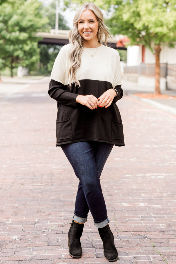 Plus Size ivory and black colorblock sweater with a crew neck, long sleeves, and front pockets.