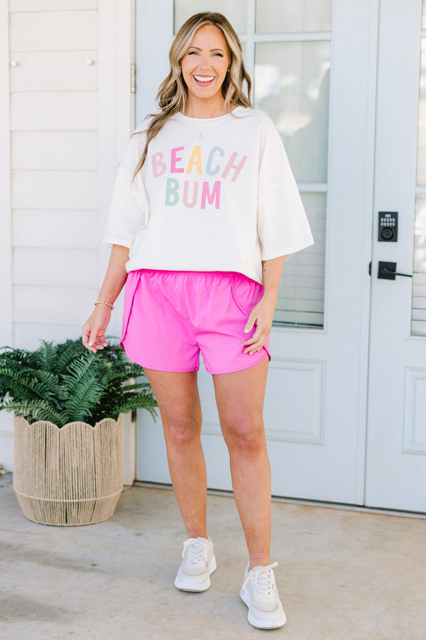 Plus Size ivory oversized boyfriend tee with colorful pastel Beach Bum graphic and crew neckline.