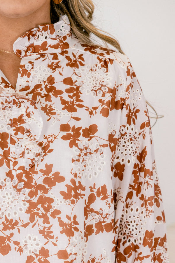 Chic Soul plus size clothing, ivory top with long sleeves that have a ruffle detail at the bottom of each sleeve as well a orange floral pattern and eyelet details throughout the top 