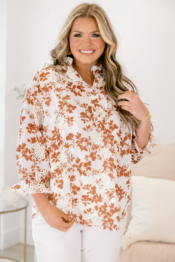 Chic Soul plus size clothing, ivory top with long sleeves that have a ruffle detail at the bottom of each sleeve as well a orange floral pattern and eyelet details throughout the top 