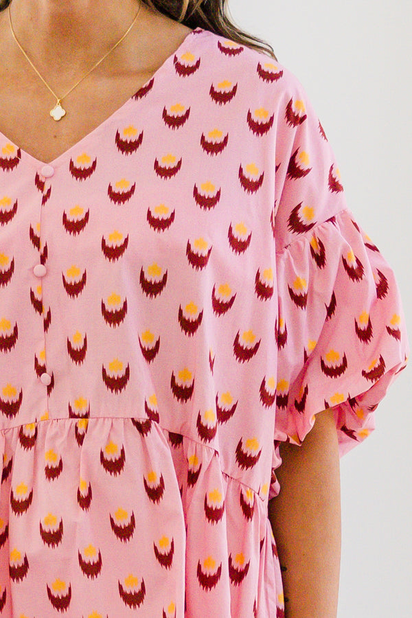 Chic Soul plus size clothing, pink short sleeve baby doll blouse with button up detail down the front with v neckline with bubble sleeves with abstract yellow/fuchsia print