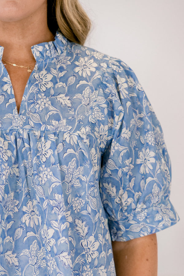 Plus Size blue floral cotton top with short puff sleeves, a ruffled neckline, and a relaxed fit.