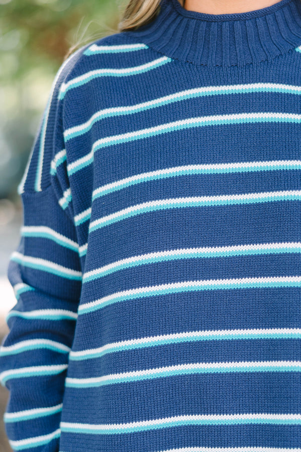 Plus Size navy rollneck sweater with horizontal teal and white stripes, long sleeves, and relaxed fit.