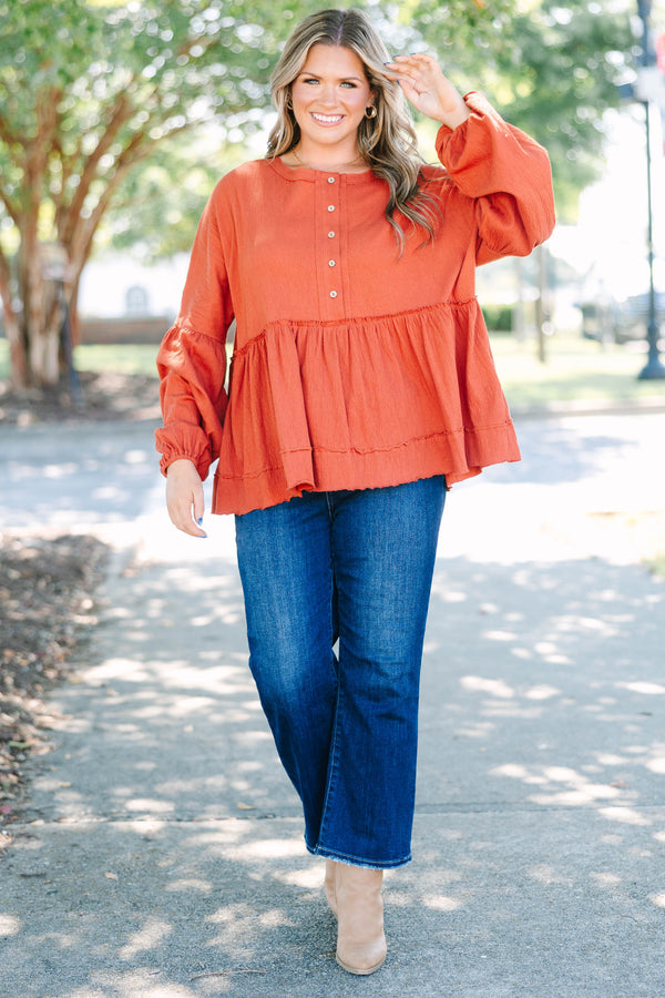 Plus Size rust-colored babydoll top with long puff sleeves, a button-down front, and textured fabric.