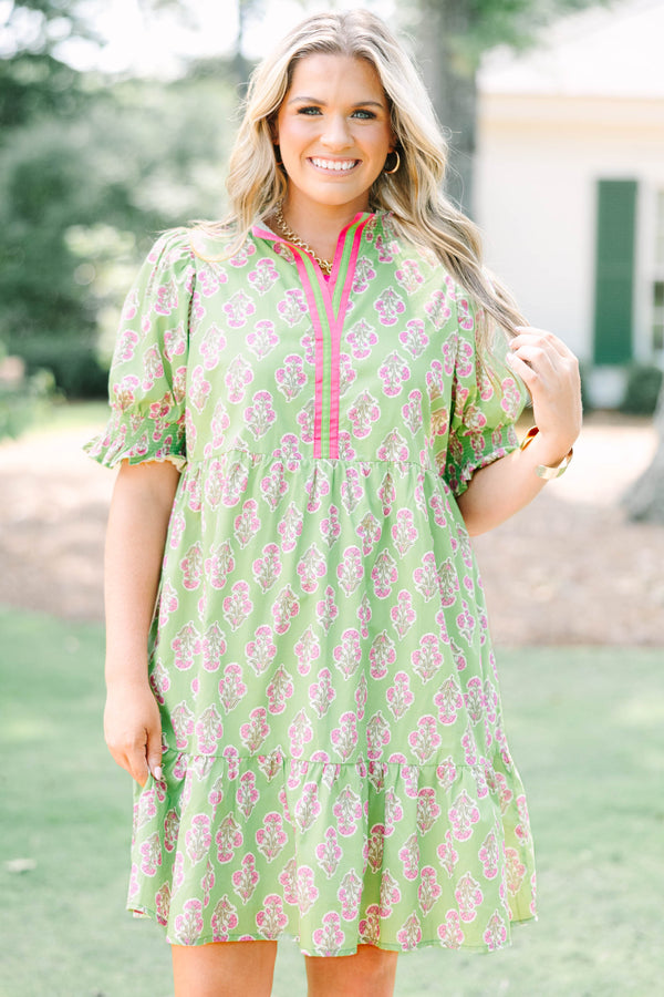 Plus Size green floral mini dress with pink trim, V-neckline, and short puff sleeves.