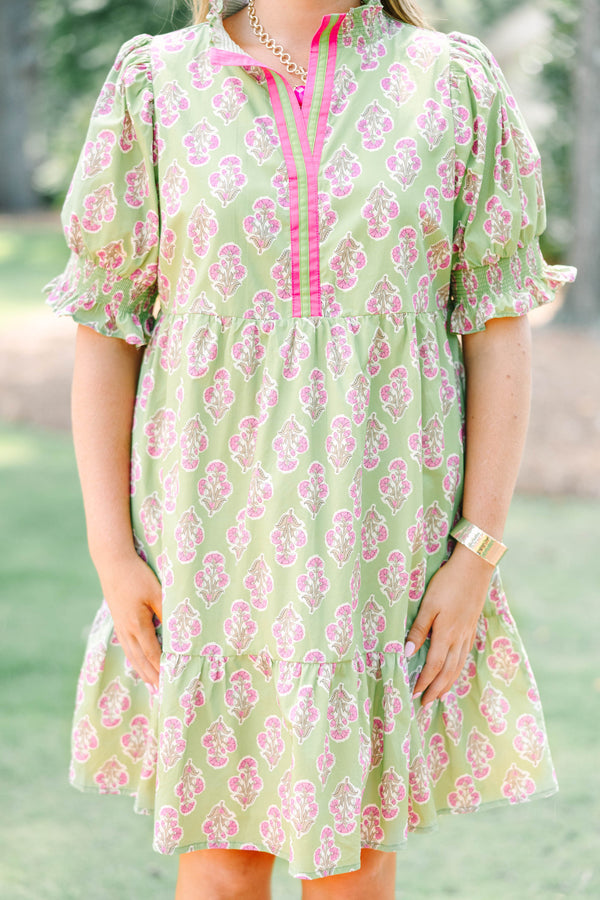 Plus Size green floral mini dress with pink trim, V-neckline, and short puff sleeves.