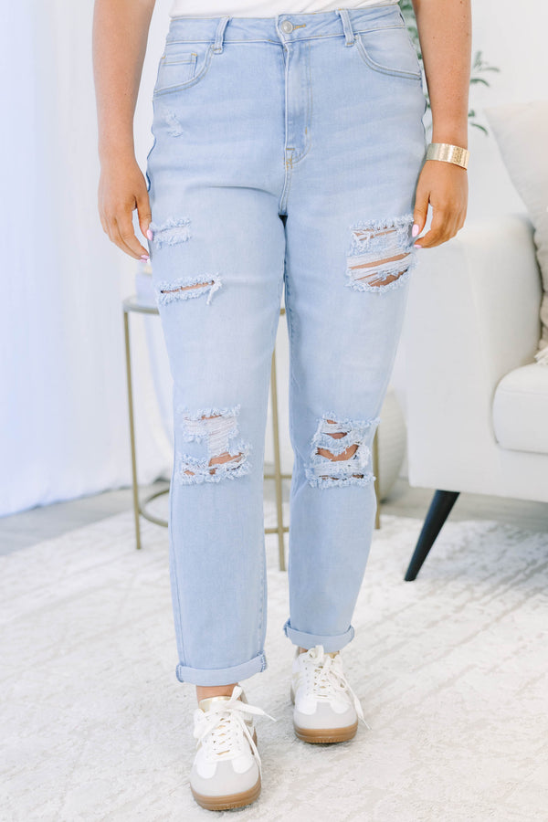 Plus Size light wash distressed jeans with a relaxed fit and rolled cuffs.