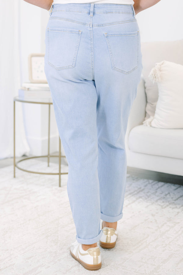 Plus Size light wash distressed jeans with a relaxed fit and rolled cuffs.