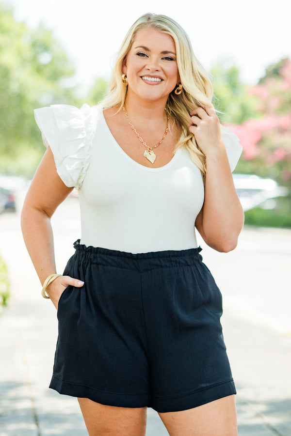 Plus Size black shorts with an elastic waistband, side pockets, and a relaxed fit.
