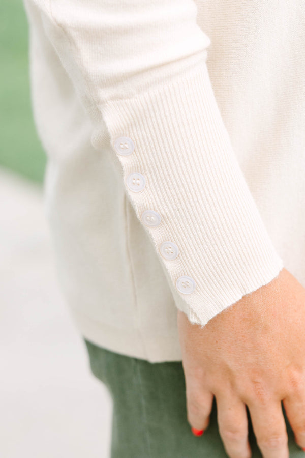 Plus Size beige relaxed fit knit sweater with a round neckline and button-cuffed long sleeves.
