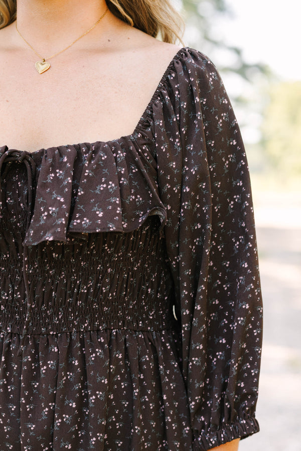 Plus size brown floral midi dress with a smocked waist, ruffled neckline, and flowy long sleeves.