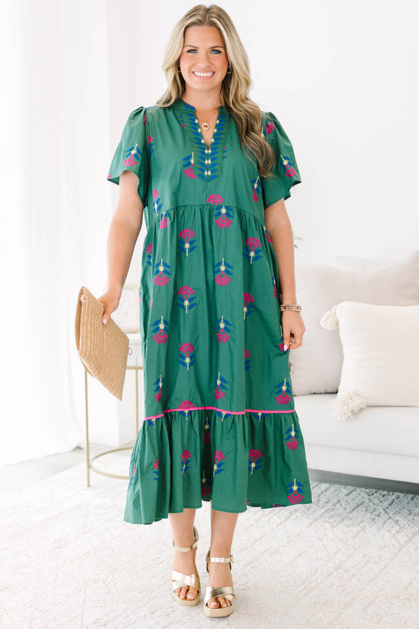 Plus size hunter green midi dress with pink floral embroidery, flowy fit, and tiered ruffle hem.
