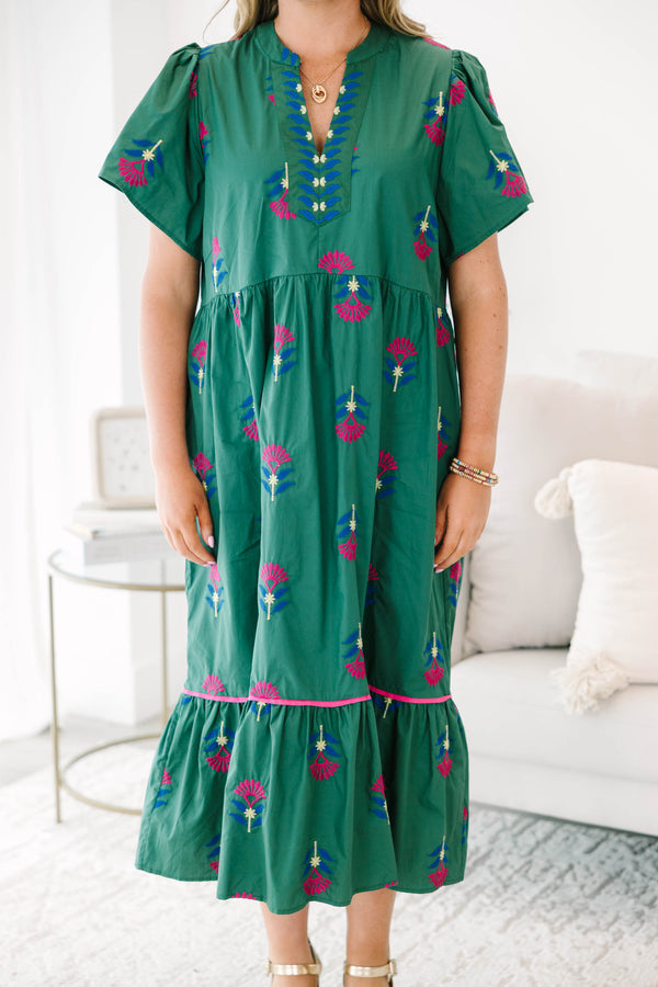 Plus size hunter green midi dress with pink floral embroidery, flowy fit, and tiered ruffle hem.