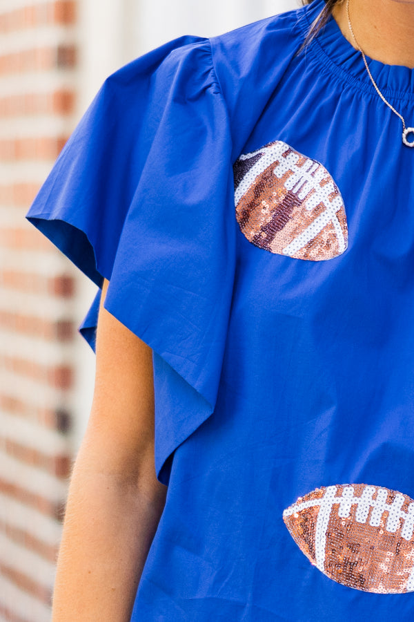 Chic Soul plus size clothing, short-flutter-sleeve blue top with smocked neckline and brown sequined football patches scattered across top 
