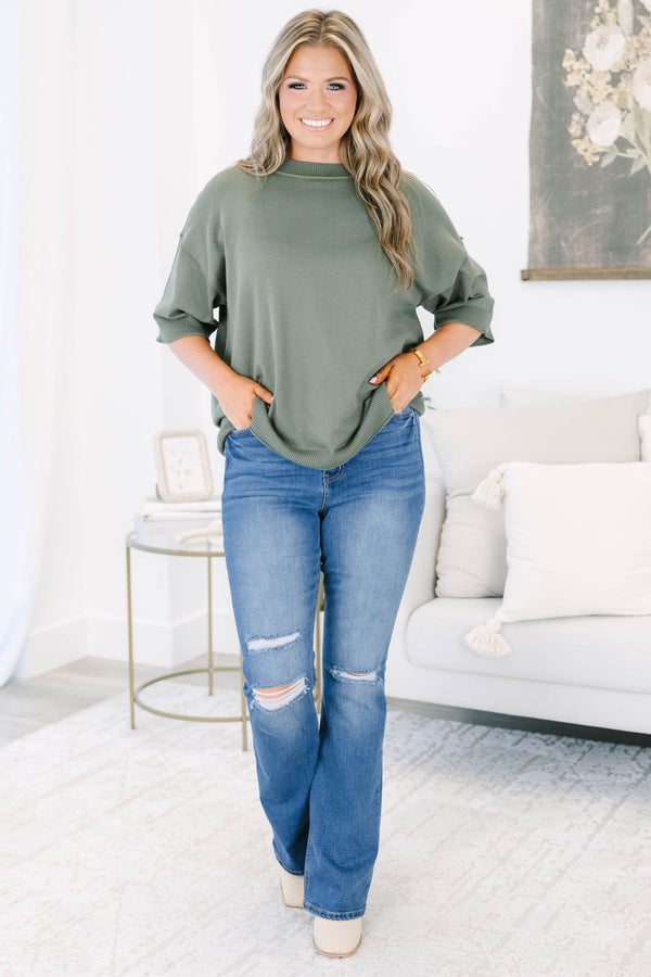 Plus size medium wash flare jeans with distressed knee details and a comfortable high-rise fit.