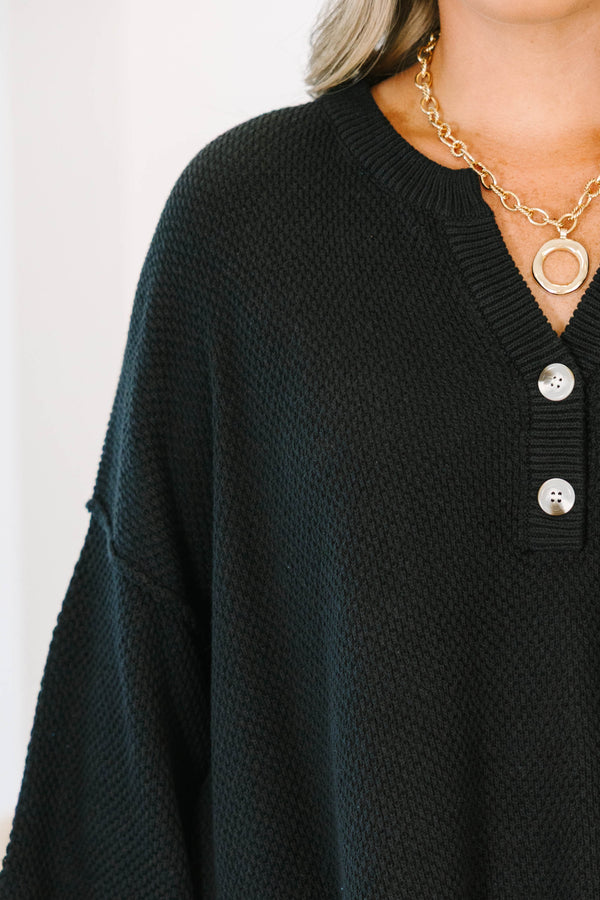 Plus Size black oversized knit top with a button-up henley neckline and three-quarter sleeves.