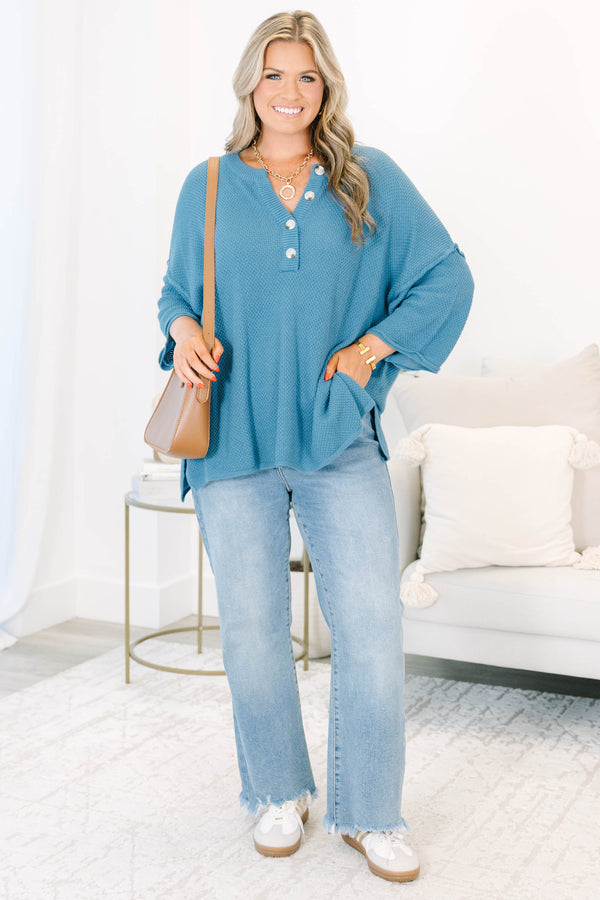 Plus Size blue knitted henley top with a relaxed fit, button neckline, and side slits.