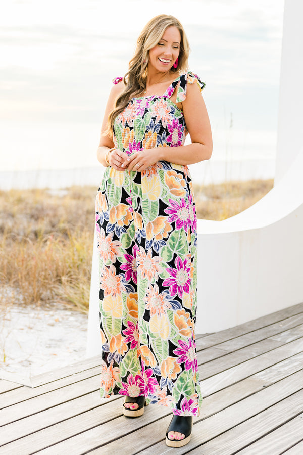 Chic Soul plus size clothing, black sleeveless flowy jumpsuit with a smocked bodice and tied straps with a multi-colored floral pattern