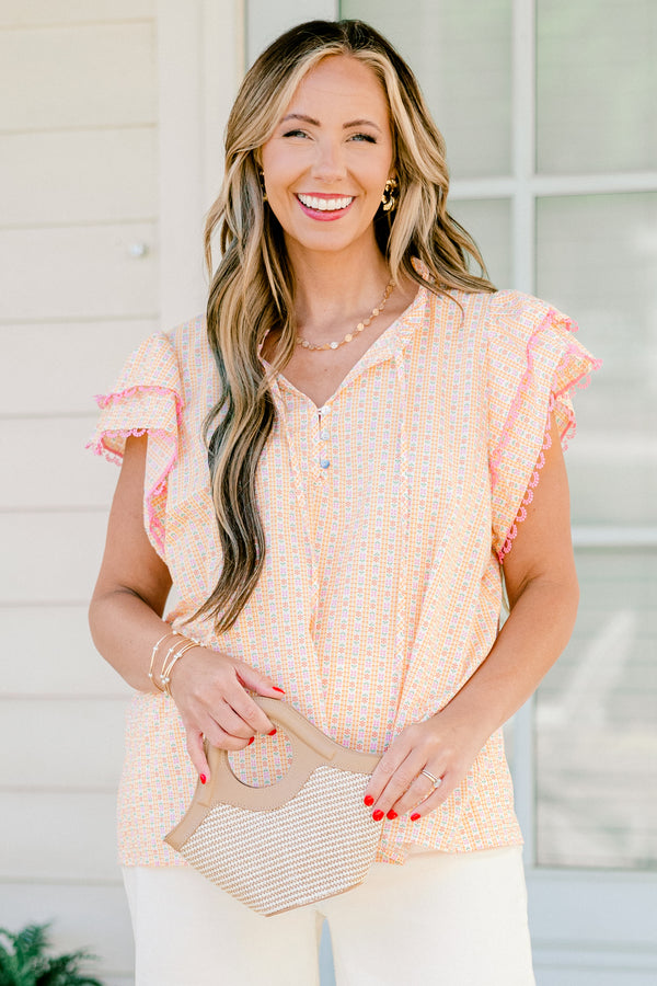 Plus Size pink ditsy floral top with flutter sleeves, tassel ties, and functional buttons.