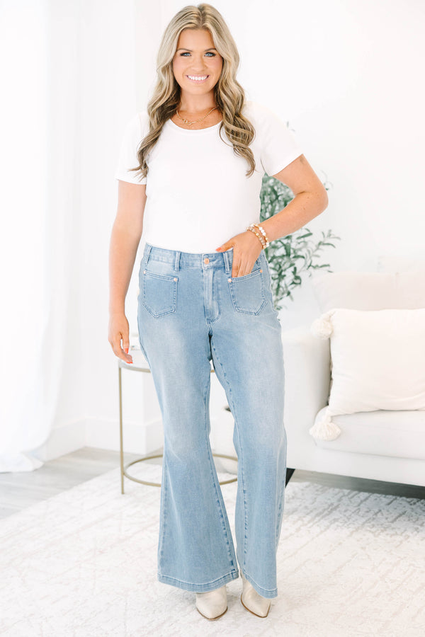 Plus Size medium wash flare jeans with front patch pockets and a high-waisted fit.