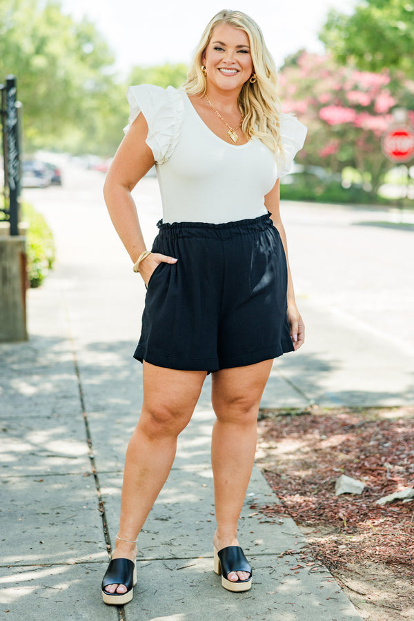Plus Size black shorts with an elastic waistband, side pockets, and a relaxed fit.