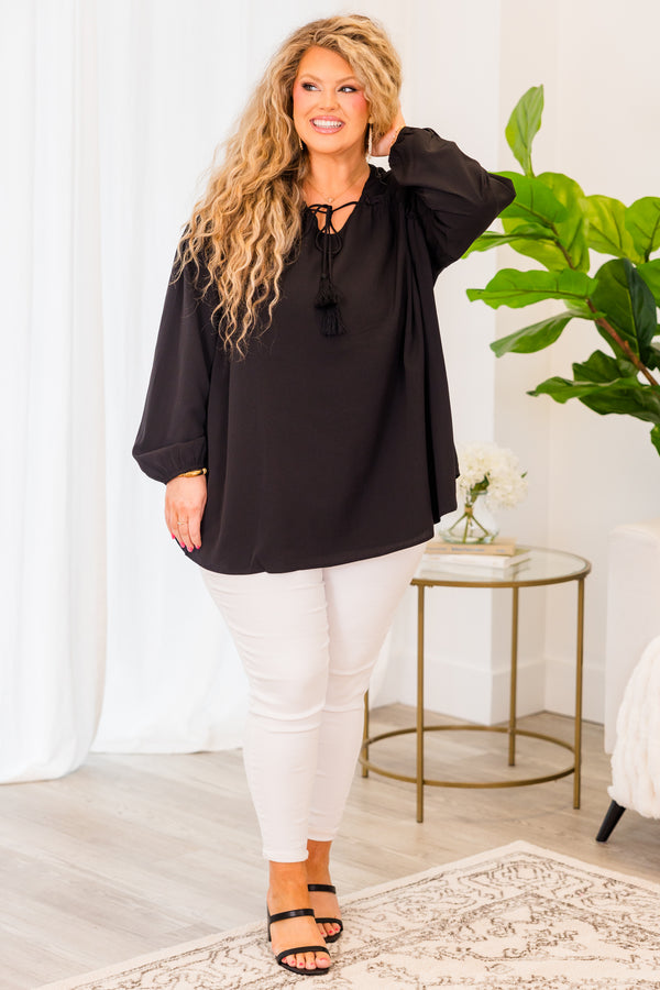 Plus Size black flowy top with long sleeves, a V-neckline, and a tassel tie detail.
