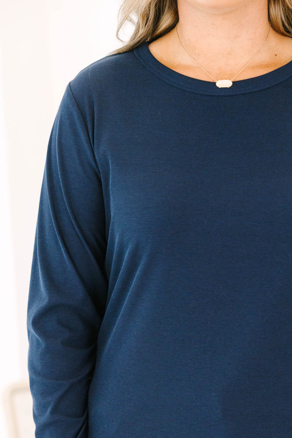 Plus size woman in a navy long sleeve crewneck top with a soft, stretchy fit.