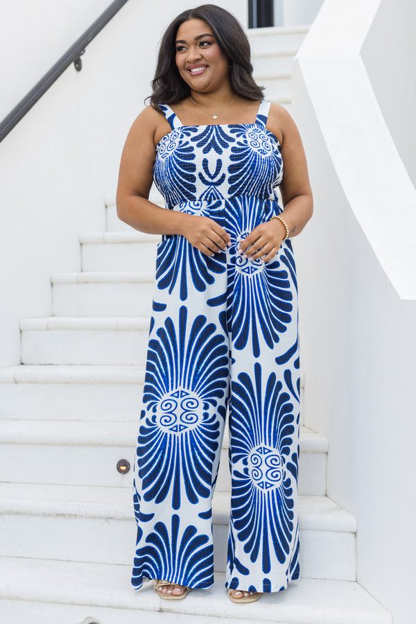 Chic Soul plus size clothing, blue sleeveless jumpsuit with smocked detailing on the chest area and a blue palm abstract pattern throughout