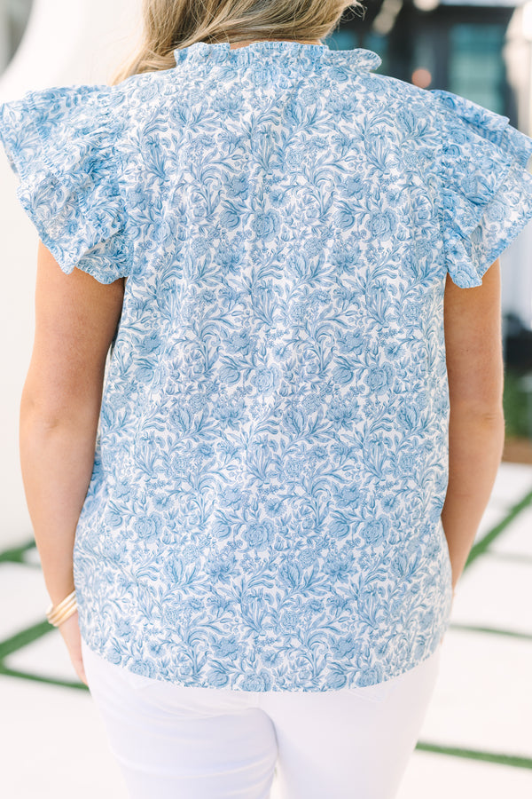 Chic Soul plus size clothing, light blue top with flutter sleeves a slight v-neckline as well a a ruffle detail on the neckline and a floral pattern throughout