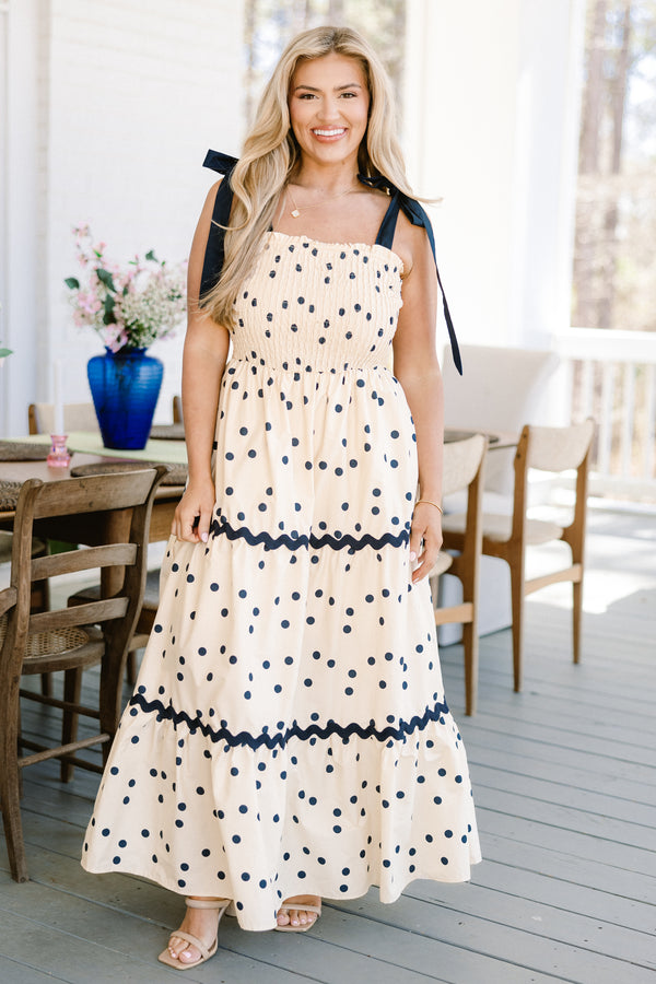 Chic Soul plus size clothing, ecru cream ruffled maxi dress with a square-neckline with black bow ties on the shoulders and a smocked bodice with a ric rac black lining and a black polka dotted pattern 