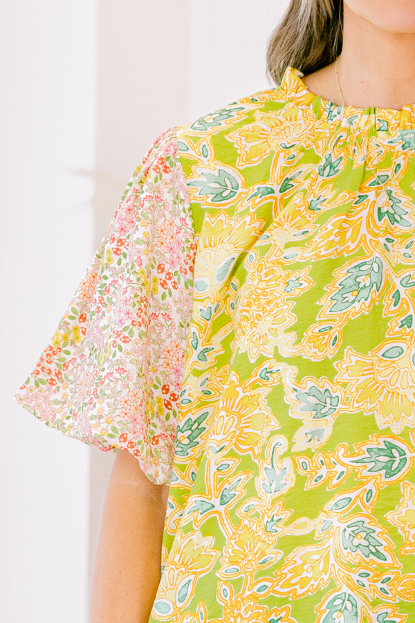 Plus Size green top with abstract print bodice and contrast floral elastic puff sleeves.