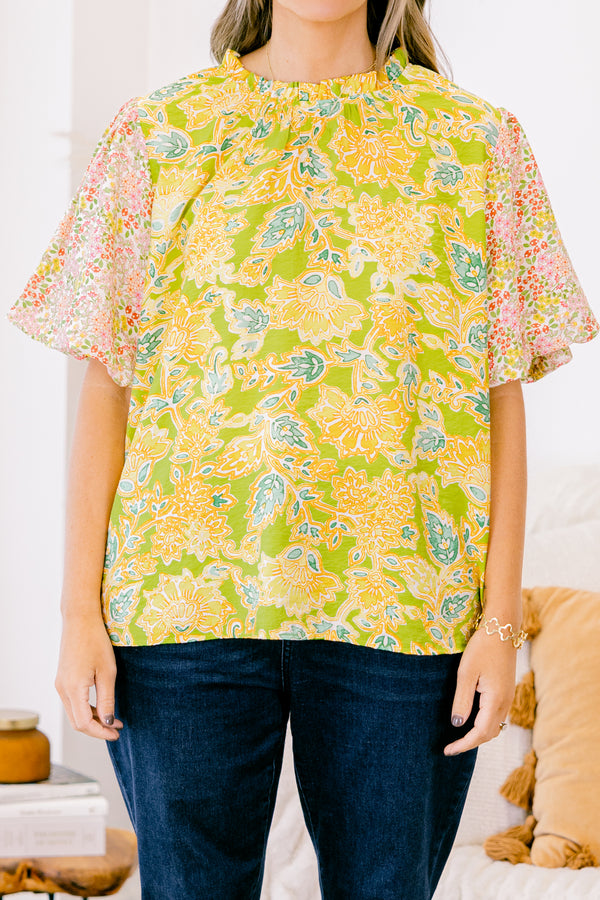 Plus Size green top with abstract print bodice and contrast floral elastic puff sleeves.