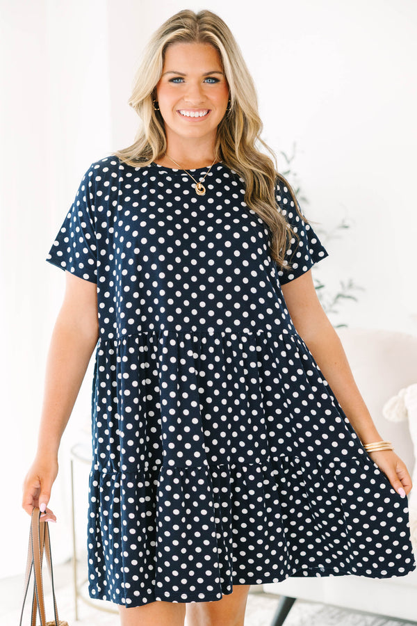 Plus Size navy polka dot babydoll dress with short sleeves, a round neckline, and tiered skirt.