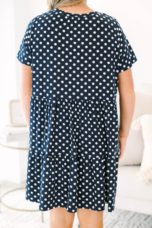 Plus Size navy polka dot babydoll dress with short sleeves, a round neckline, and tiered skirt.