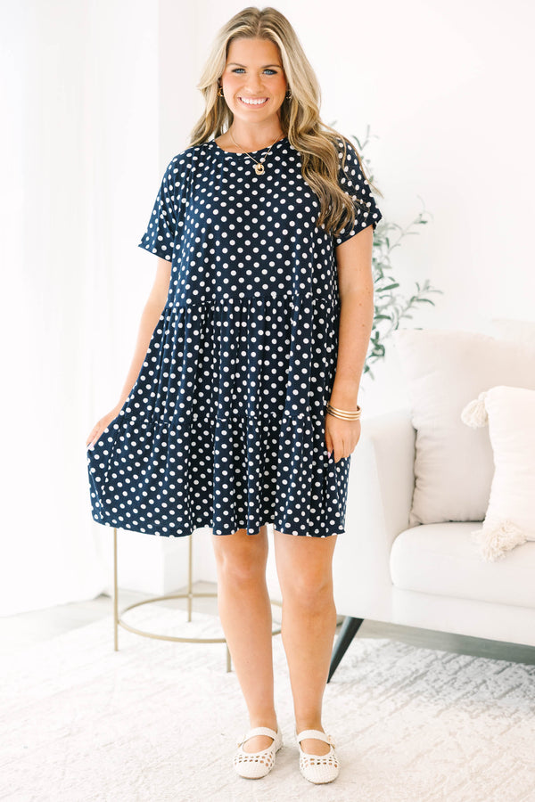 Plus Size navy polka dot babydoll dress with short sleeves, a round neckline, and tiered skirt.