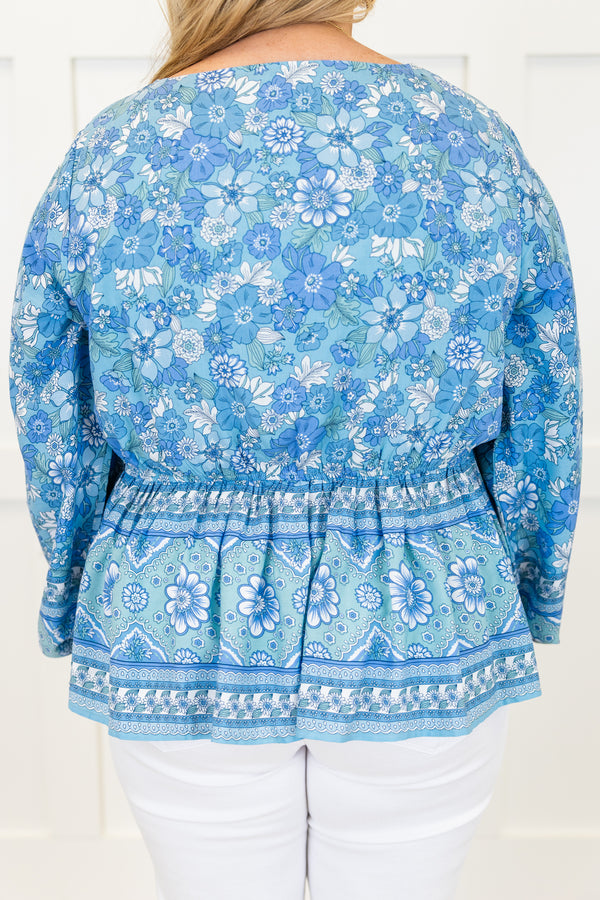 Chic Soul plus size clothing, long-sleeve blue baby doll top with a v-neckline and smocked detailing with a tie on the waist with a darker blue floral pattern 