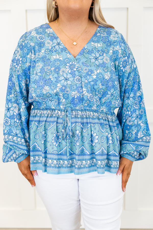 Chic Soul plus size clothing, long-sleeve blue baby doll top with a v-neckline and smocked detailing with a tie on the waist with a darker blue floral pattern 