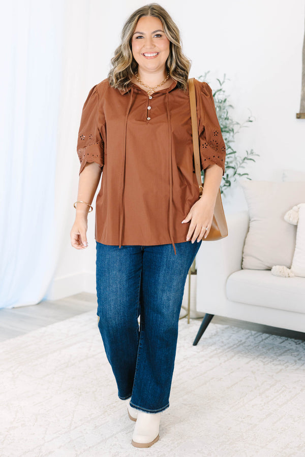 Plus Size brown short sleeve top with eyelet embroidery on the sleeves and a button-up neckline.