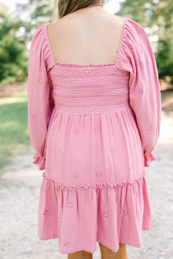 Plus size pink cotton dress with smocked bodice, long puff sleeves, and floral embroidery.