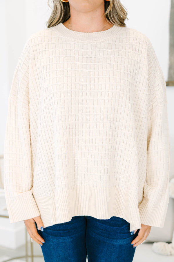 Plus size cream oversized knit sweater with a textured grid pattern and side slits.