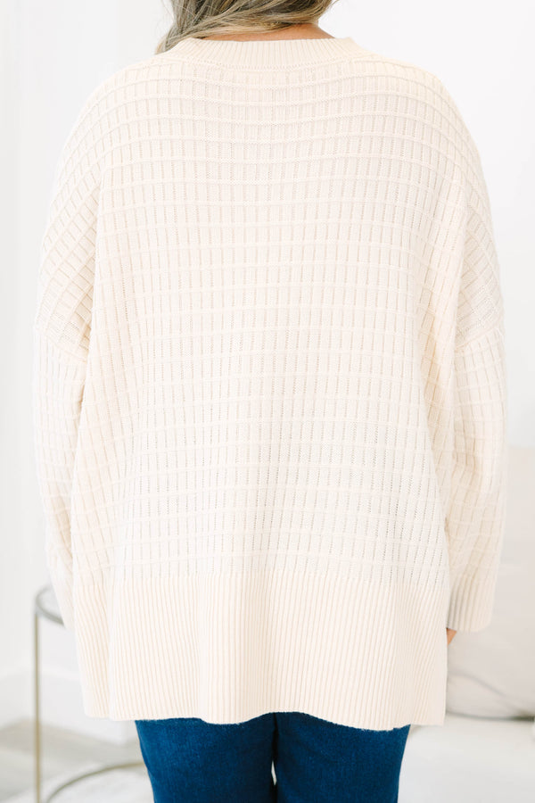 Plus size cream oversized knit sweater with a textured grid pattern and side slits.