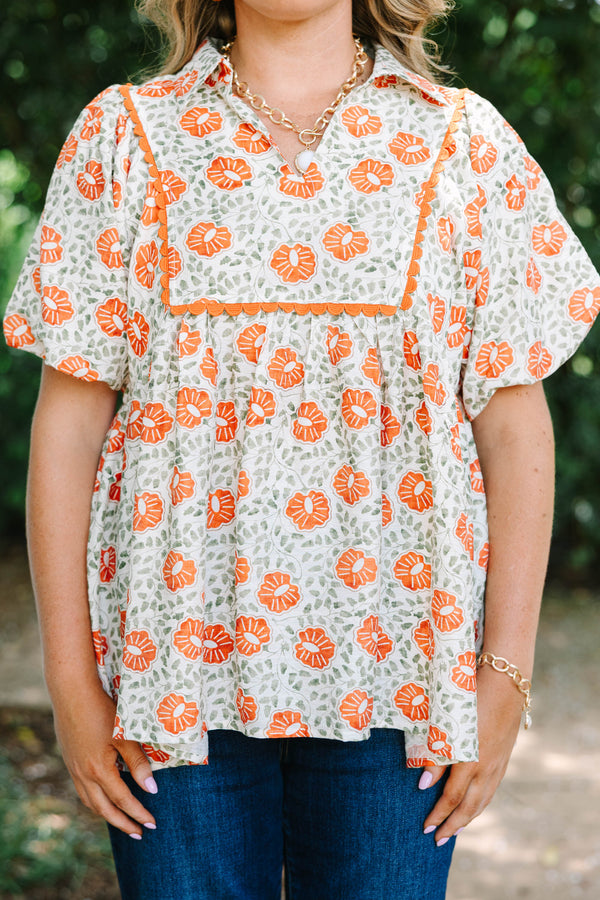 Plus Size floral babydoll top in burnt orange and green with a square yoke and short puff sleeves.